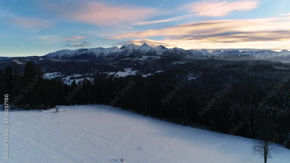 Snow capped mountains in the winter, aerial view. Aerial view of winter mountain landscape and colorful sunset sky. Tatra high mountains and magical unspoiled scenery. Snow capped mountains in the winter, aerial view. Aerial view of winter mountain landscape and colorful sunset sky. Tatra high mountains and magical unspoiled scenery.