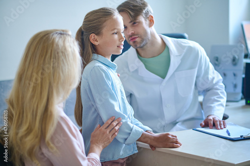 Profile of school age girl and man looking at ear © zinkevych