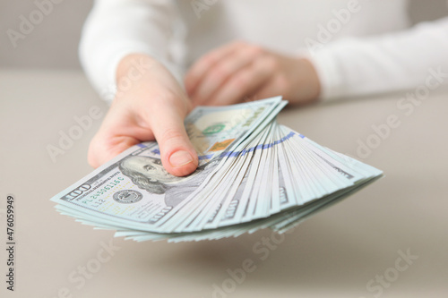 Many dollar bills in female hands close up