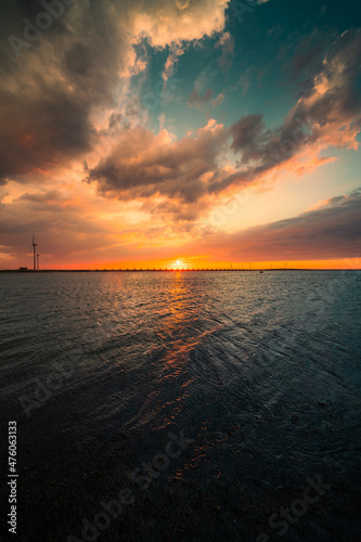 Vertical shot of the beautiful sunset above the sea. Oosterscheldekering, the Netherlands. © Andy Troy/Wirestock