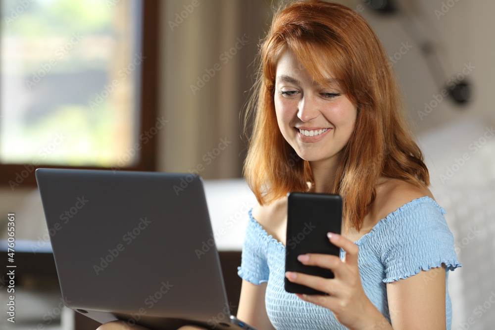 Happy woman using laptop and phone in a room Happy woman using laptop and phone in a room