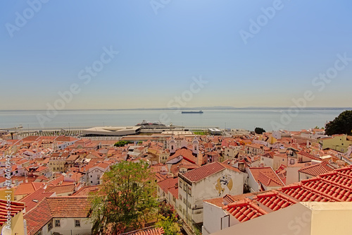 Tiled rooftops of the houses of Lisbon, with Tagus river in the background, Portugal photo
