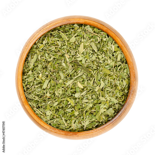 Hemp tea leaves, in a wooden bowl. Dried hemp leaves, Cannabis sativa, to be used as tea, spice, incense or as addition to the bath. Pure hemp from the leaf of the hemp plant, without seeds and stems.