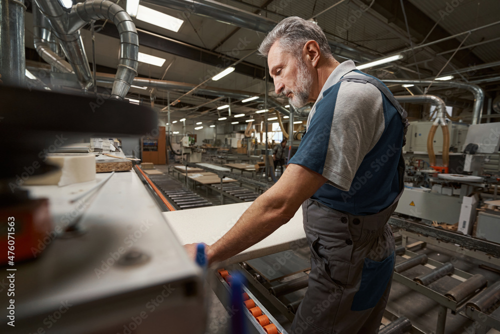 Concentrated mature man working in modern carpentry Concentrated mature man working in modern carpentry