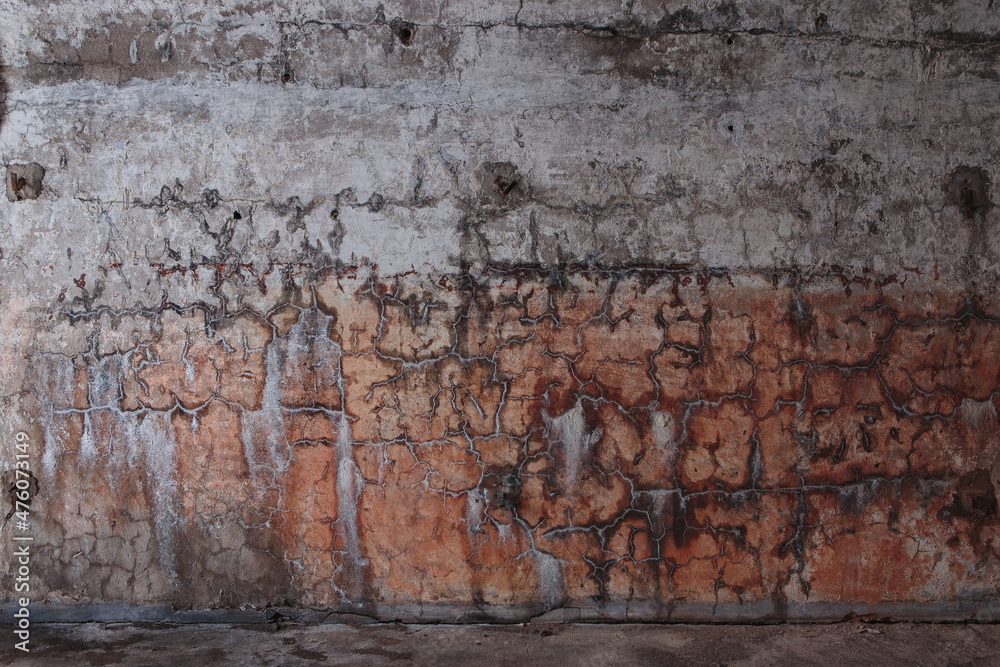 Cracked plaster on the concrete wall of an abandoned fort