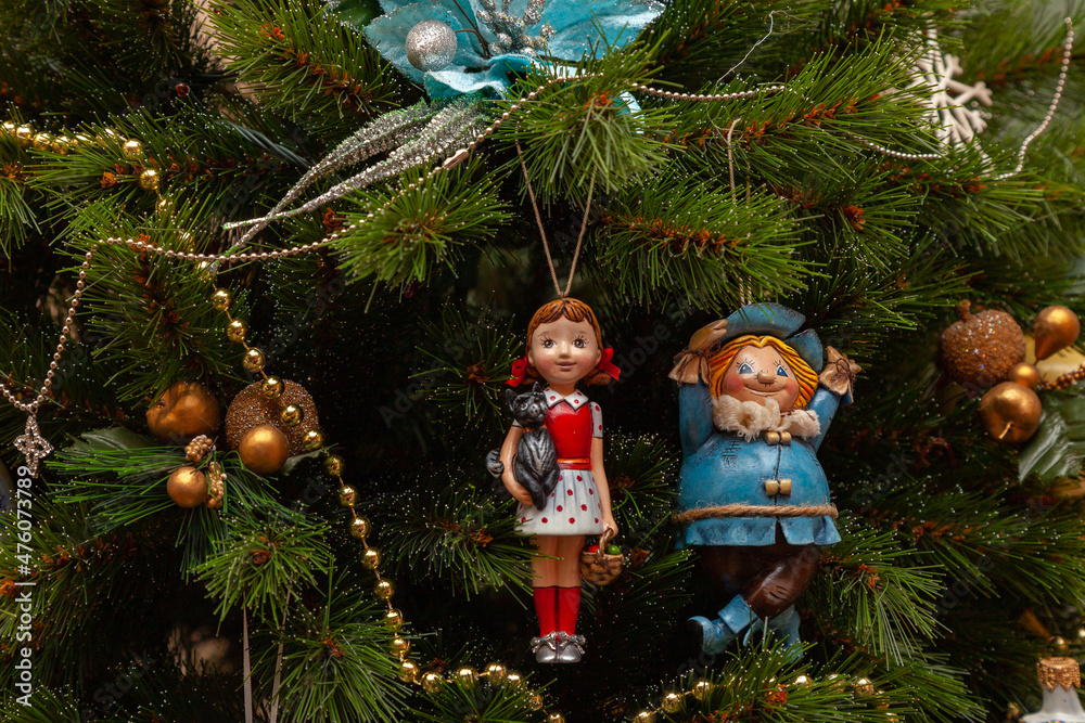 Christmas toys in the form of fairytale characters hang on the branches of a Christmas tree