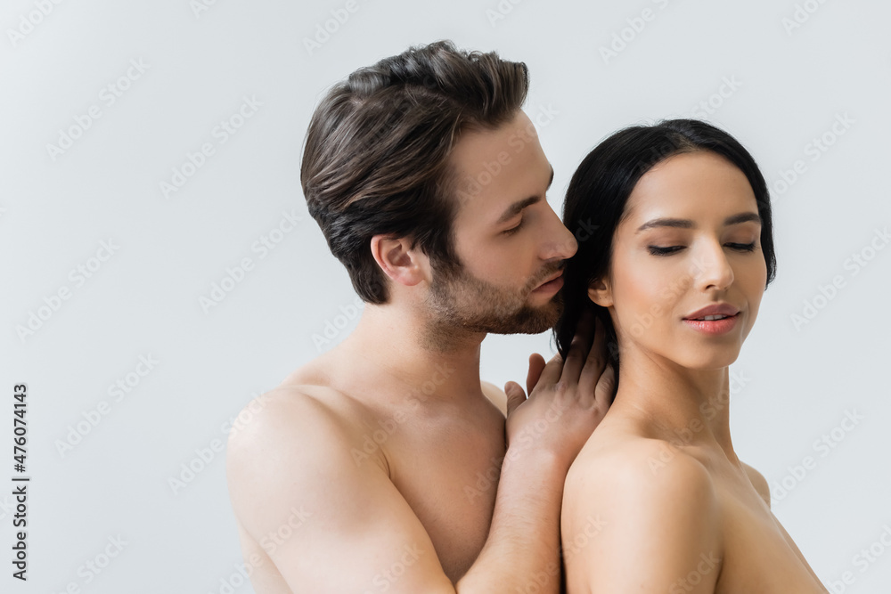 young shirtless man seducing brunette woman while touching her hair isolated on grey. young shirtless man seducing brunette woman while touching her hair isolated on grey.