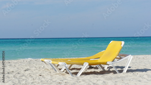 Cuba, February 2012, yellow sun lounger on a white sand beach against the backdrop of a turquoise sea
