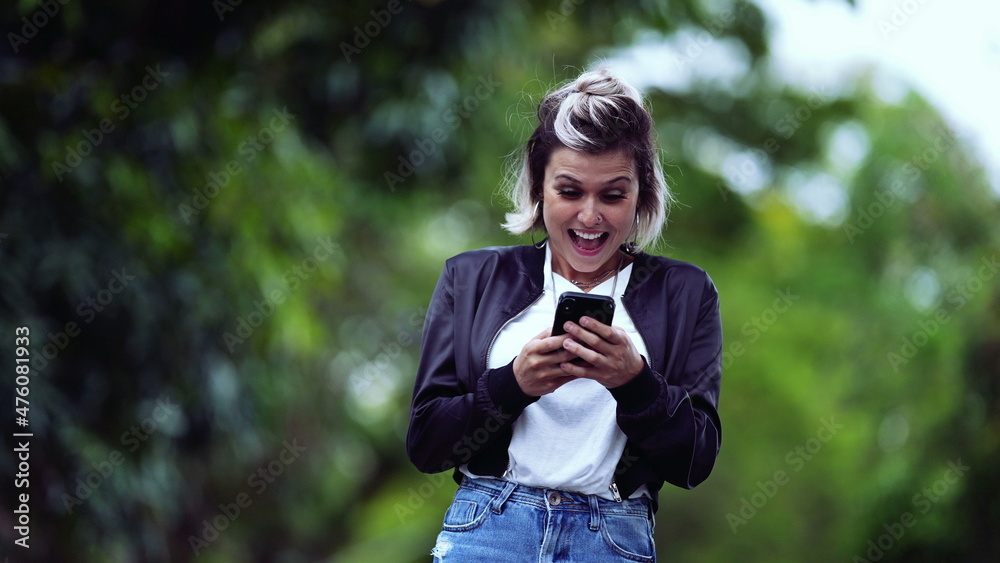 Joyful girl receiving successful message on phone
