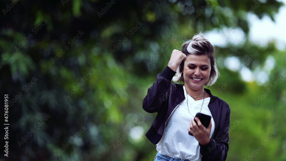 Joyful girl receiving successful message on phone Joyful girl receiving successful message on phone