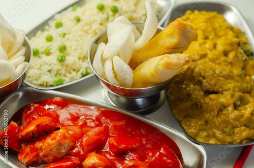 Chinese set,  chicken curry, sweet and sour chicken served with egg fried rice, vegetable spring rolls, and prawn crackers photo