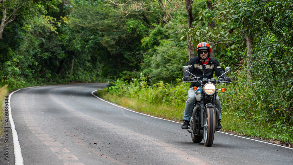 man riding his classic motorcycle at Khao Yai national park