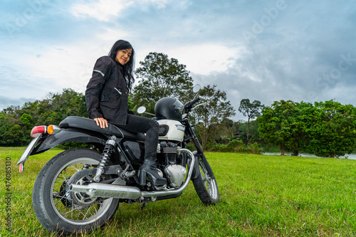 woman sitting on classic motorcycle at Khao Yai national park photo