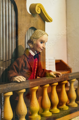 Wooden painted figurine of an organist in a church.