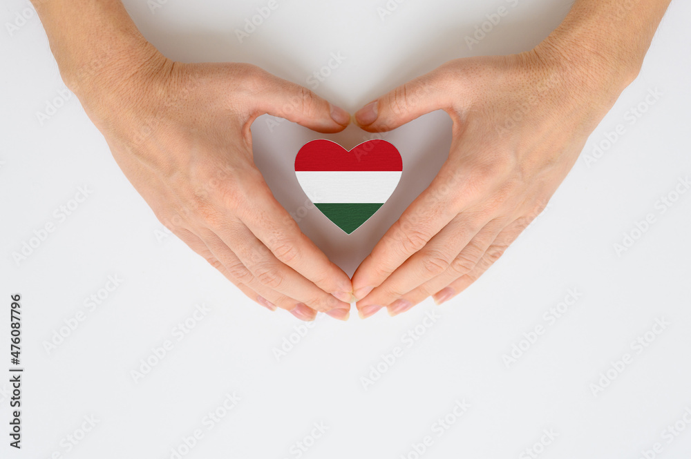 Fototapeta premium The national flag of Hungary in female hands. The concept of patriotism, respect and solidarity with the citizens of Hungary.