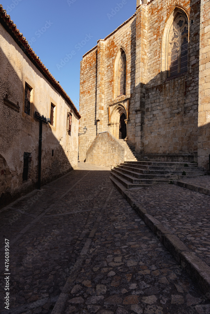 Old stone buildings in the narrow streets of the medieval city of Trujillo with the church of Santa Maria la Mayor in the background, Caceres, Extremadura, Spain