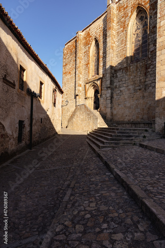 Old stone buildings in the narrow streets of the medieval city of Trujillo with the church of Santa Maria la Mayor in the background  Caceres  Extremadura  Spain