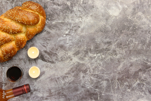 Shabbat Shalom - challah bread, shabbat wine and candles on wooden table