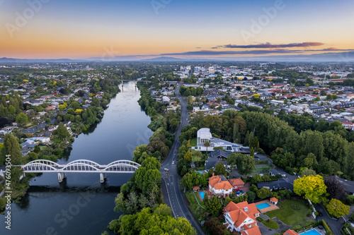 Aerial drone view at sunset, looking up the Waikato River towards the CBD, over the city of Hamilton (Kirikiriroa) in the Waikato region of New Zealand.