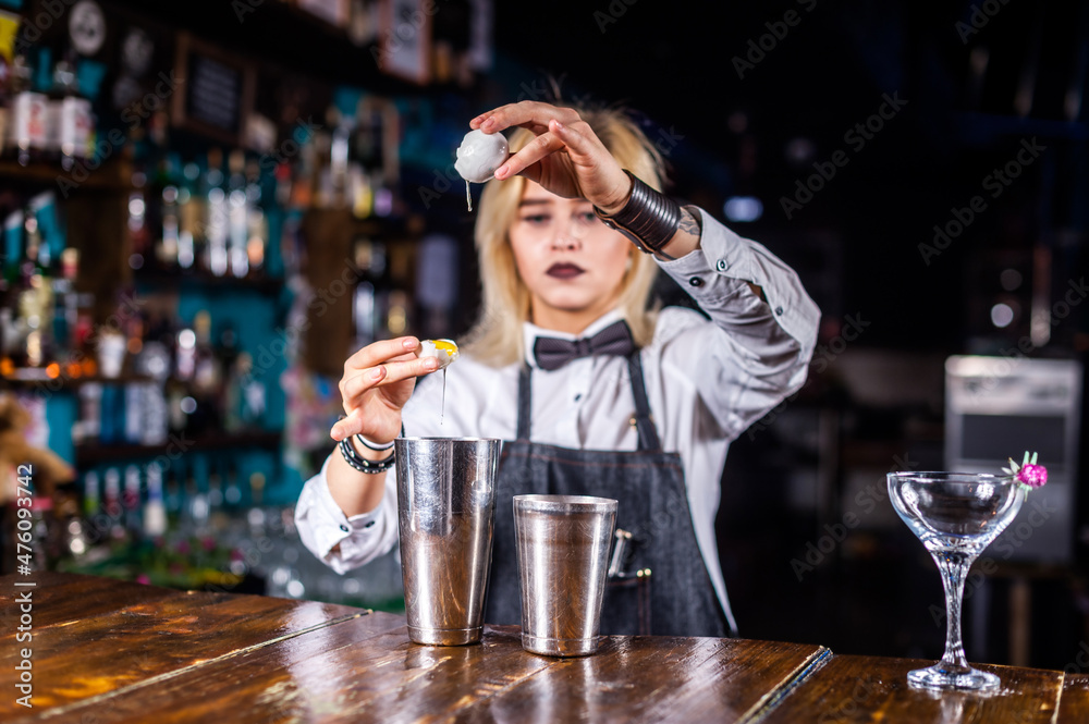Girl bartender makes a cocktail at the beerhall
