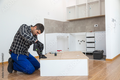 The carpenter finalizing the assembly of the kitchen shelf