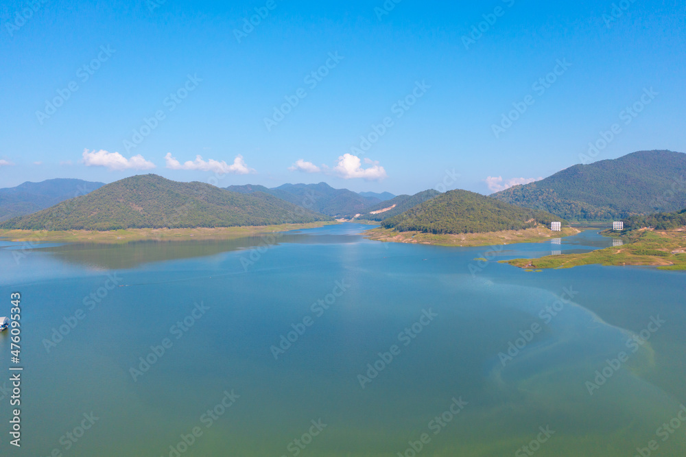 Aerial top view of a dam with forest trees, lake, river, mountain hills in travel and environment concept. Nature landscape background in Thailand.