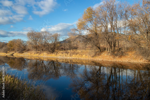 Trees reflecting in the Okanagan River in autumn © Lynda