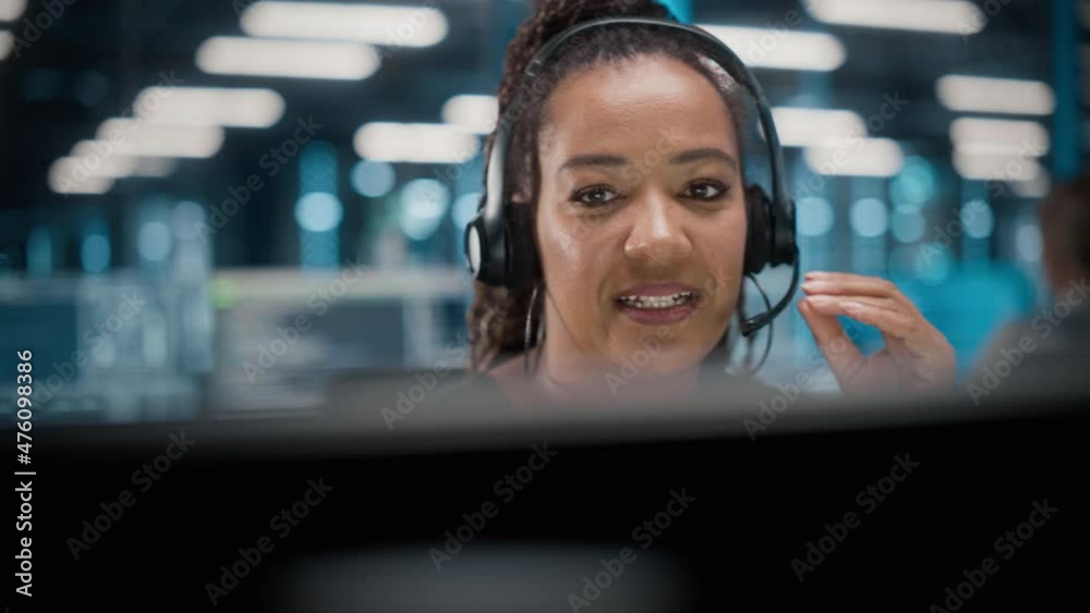 Call Center Office: Portrait of Friendly African American Female Technical Customer Support Specialist Talking on a Headset, uses Computer. Client Experience Officer Helps Online via Video Conference