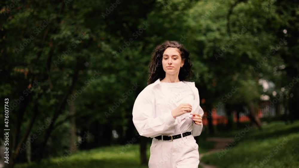 Slow motion of young beautiful curly hair girl spinning in the park. Attractive fashion model with flying hair. Beautiful girl woman shakes her curly hair. . High quality 4k footage Slow motion of young beautiful curly hair girl spinning in the park. Attractive fashion model with flying hair. Beautiful girl woman shakes her curly hair. . High quality 4k footage