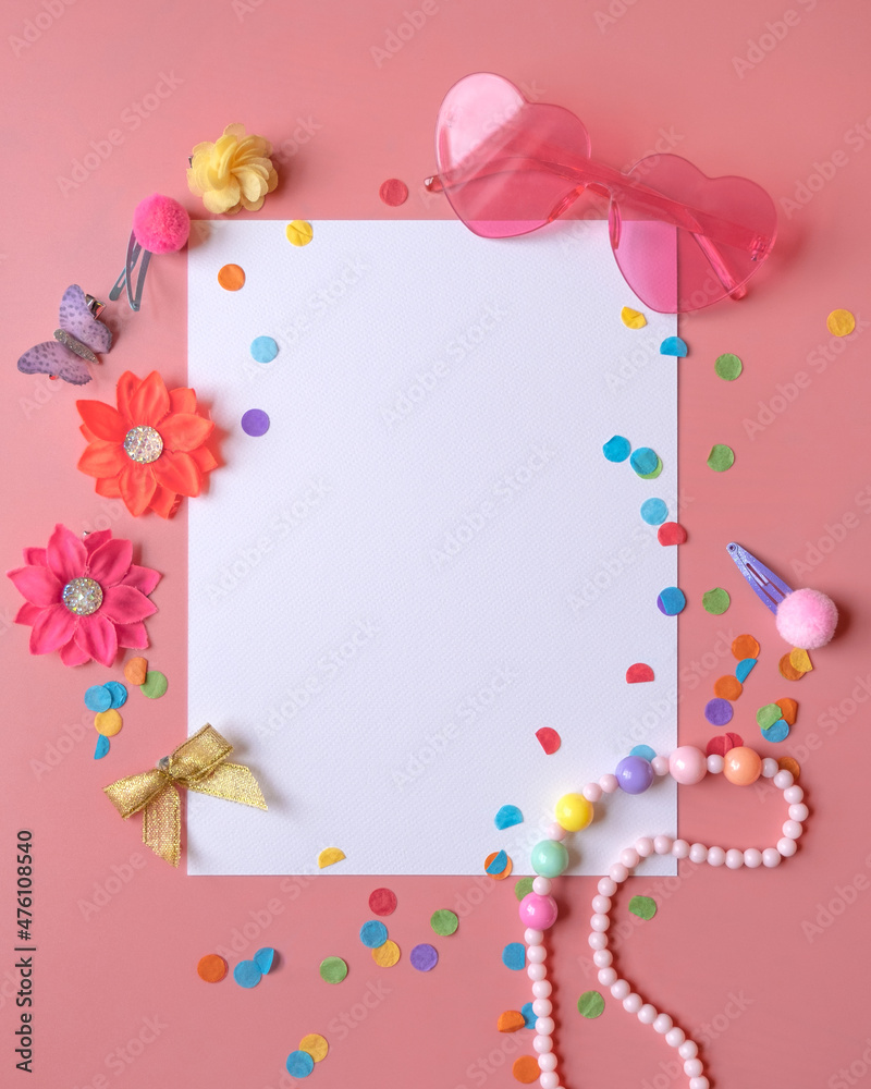 White blank paper sheet on the pink background with girly decorative elements and confetti. 