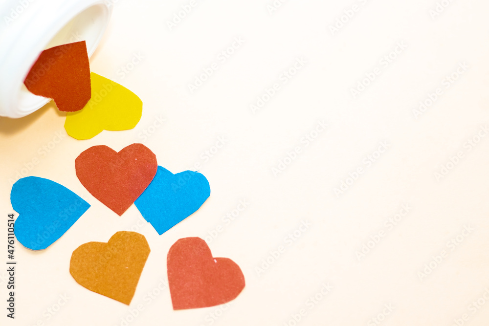 many colorful paper hearts poured on a grey background, from a pills white bottle. space for text. valentines day, i love. love and drink coffee, tea, cappuccino. yellow background. february. greeting many colorful paper hearts poured on a grey background, from a pills white bottle. space for text. valentines day, i love. love and drink coffee, tea, cappuccino. yellow background. february. greeting