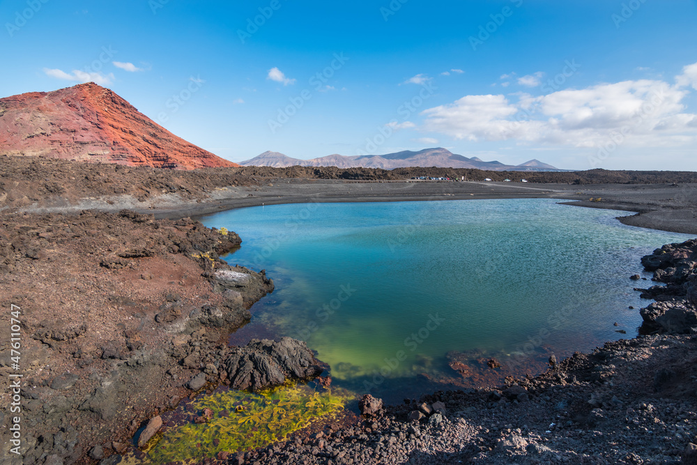 View of a beautiful lake close to the Red Mountain Beach (Playa Montanã Bermeja) and Bermeja Volcan in the background - Lanzarote, Canary Islands, Spain
