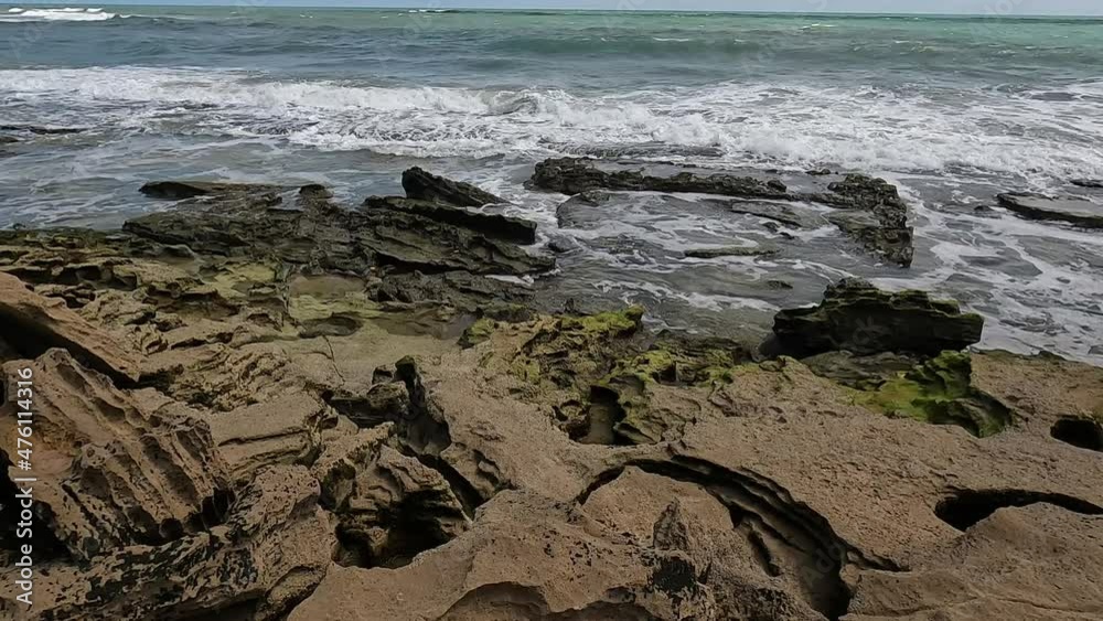 Sea water with waves on some rocks on the coast. Vacation seascape. Waves crashing on rocks with abundant foam. Sea water with waves on some rocks on the coast. Vacation seascape. Waves crashing on rocks with abundant foam.