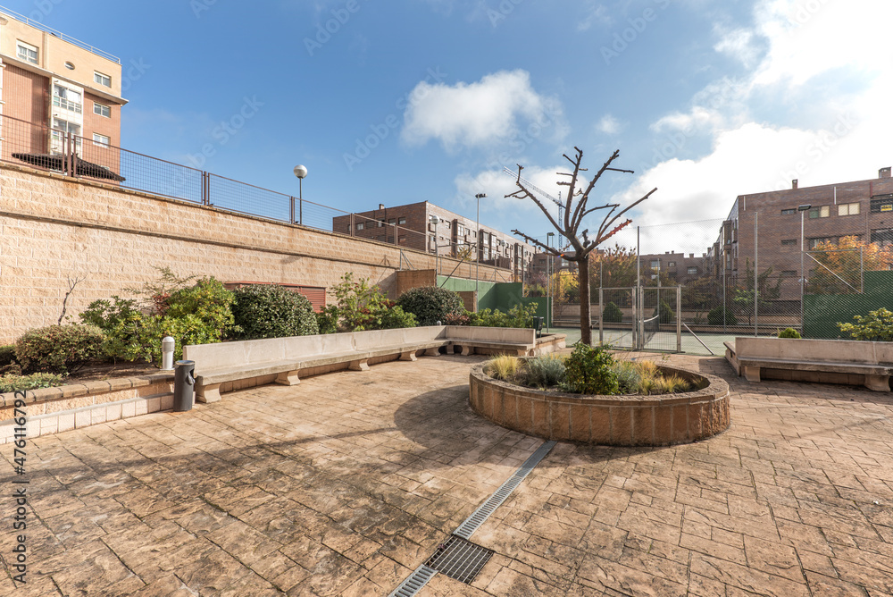 Obraz premium Common areas in an urbanization with trees, plants and a tennis court