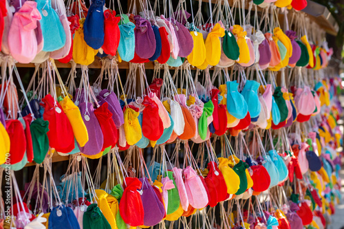 a lot of fortune colorful pouch hanged on the wooden rack in hikawa shinto shrine