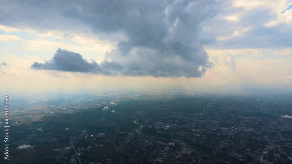 Aerial view from airplane window at high altitude of distant city covered with puffy cumulus clouds forming before rainstorm Aerial view from airplane window at high altitude of distant city covered with puffy cumulus clouds forming before rainstorm