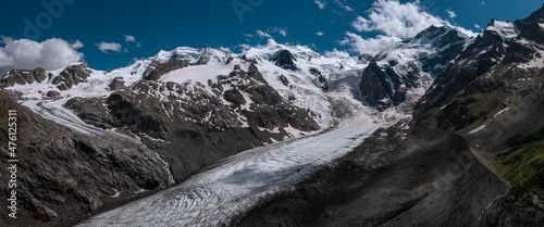 Morteratsch Glacier with snowy mountains in the Engadin in the Swiss Alps in summer with blue sky and sun.