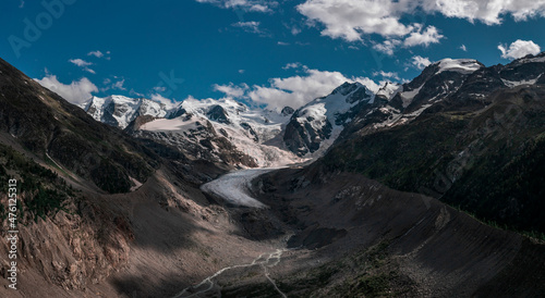 Morteratsch Glacier with snowy mountains in the Engadin in the Swiss Alps in summer with blue sky and sun. photo