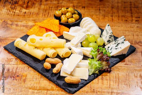 Different types of cheeses on black board.Various types of cheese .Set or assortment cheeses. Top view. Assortment of different cheese types on wooden table. Cheese background.