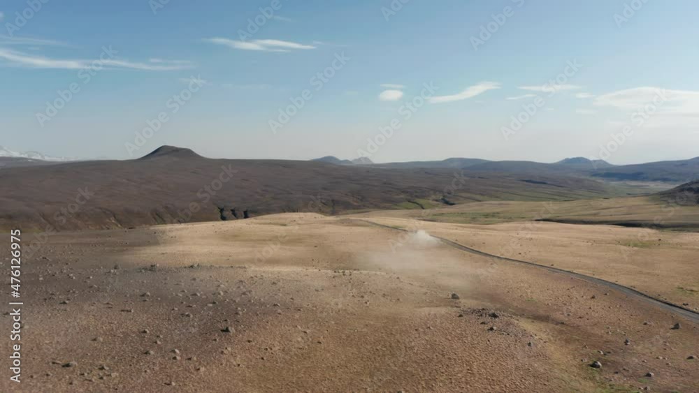 Birds eye flying above the car driving offroad through rural countryside in Iceland. Amazing moonscape icelandic landscape with vehicle driving dust road exploring highlands Birds eye flying above the car driving offroad through rural countryside in Iceland. Amazing moonscape icelandic landscape with vehicle driving dust road exploring highlands