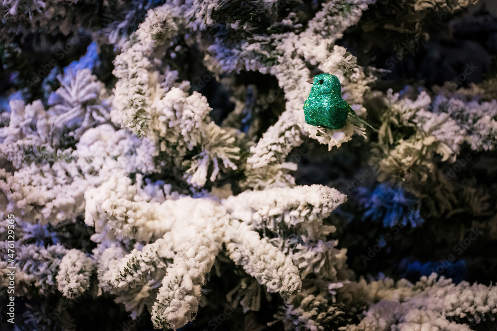Green Glitter Robin in a snowy tree. Christmas decorations on sale in a garden centre, near Lacock, England Green Glitter Robin in a snowy tree. Christmas decorations on sale in a garden centre, near Lacock, England