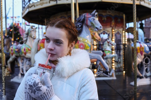 Closeup young woman with red hair on carousel one person beauty smile cute face pretty lady street walking female fun funny drinking cocktail lifestyle