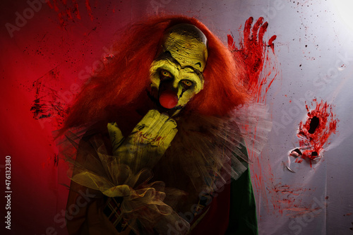 Tela Terrifying clown against bloodstained plastic film