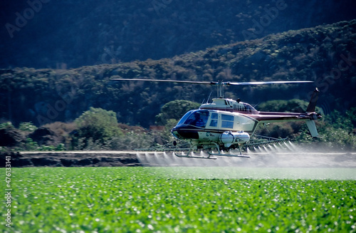 Crop dusting helicopter spraying crops.