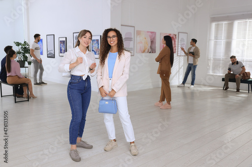 Young women at exhibition in art gallery