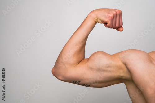 Foto Muscular Bicep on grey background