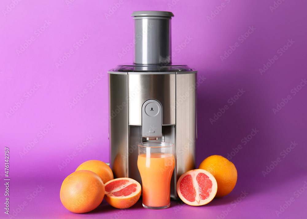 Modern juicer with fresh fruits on purple background Modern juicer with fresh fruits on purple background