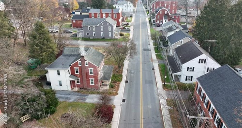 Aerial above road in small town in USA. America town during column autumn winter morning. Smoke rising from house chimney. photo