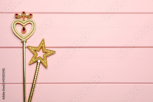 Tableau sur toile Different golden magic wands on pink wooden table, flat lay