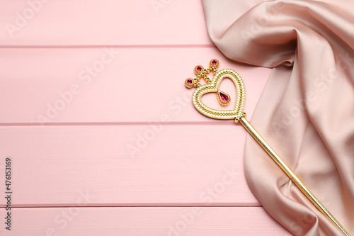 Fotografie, Tablou Beautiful golden magic wand and fabric on pink wooden table, top view